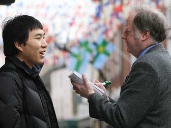 Kevin Palmer interviews student Bae Junseok from South Korea, who is studying English at the University of Derby, for a comment about the ancient game of Royal Shrovetide Football at Ashbourme, Derbyshire. This was a for a story commissioned by a national magazine. <br />